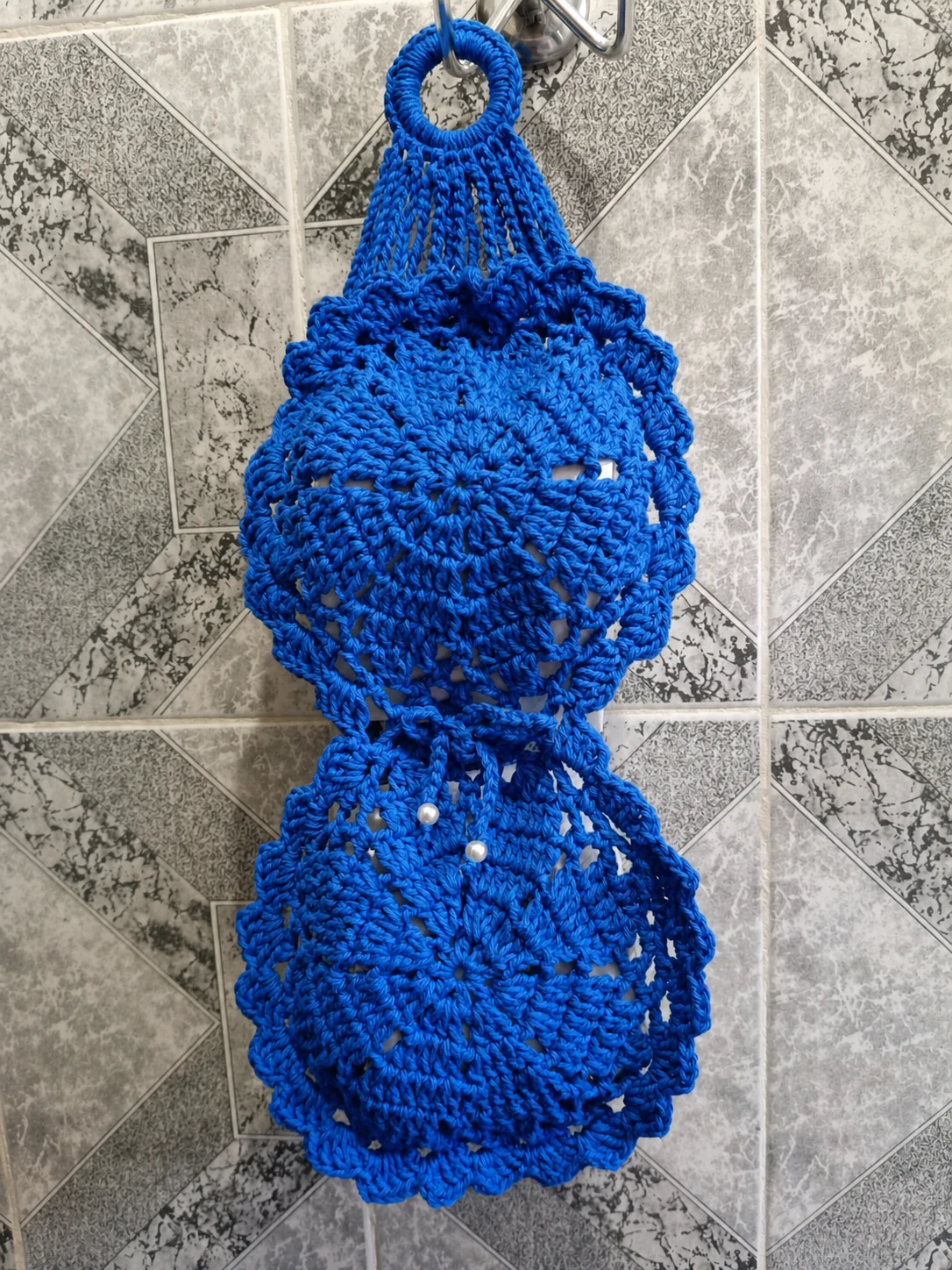 Organizador de crochê azul apoiado em uma superfície clara