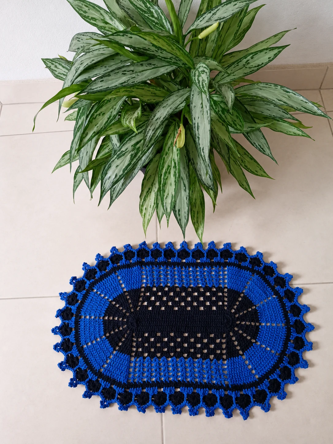 Tapete oval de crochê azul e preto no chão